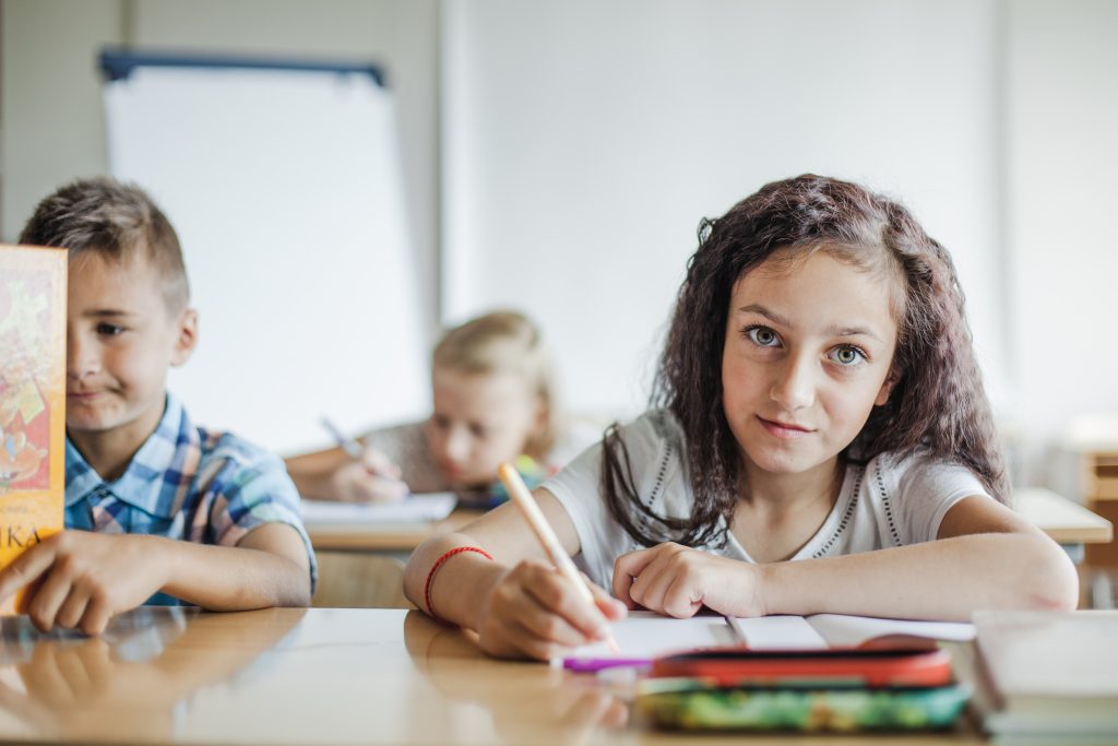 girl-sitting-table-writing